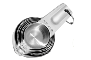 a set of 7 stainless steel measuring cups nested into each other with a ring holding them together at the end of their handles