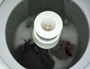 how to clean baseball pants - Image of the inside of a washing machine with some water and soap suds.